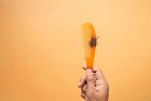 Woman checking hair in comb – hair fall home remedy image